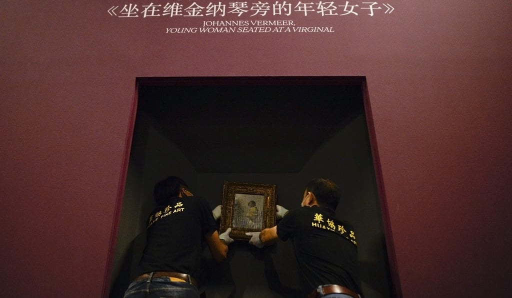 Staff of a professional art transport company hang Johannes Vermeer's ‘Young Woman Seated at a Virginal’ for the Masterpieces from The Leiden Collection exhibition at the National Museum in Beijing. Photo: AFP Staff of a professional art transport company hang Johannes Vermeer's ‘Young Woman Seated at a Virginal’ for the Masterpieces from The Leiden Collection exhibition at the National Museum in Beijing. Photo: AFP