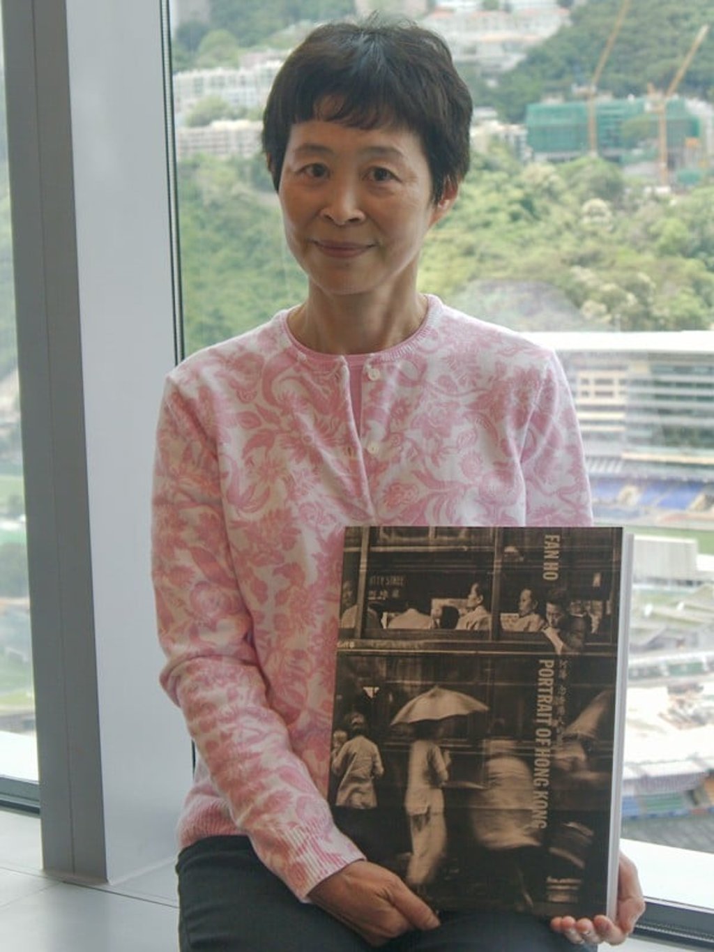 Claudia Siman Ho, with her father’s book, Portrait of Hong Kong. Picture: Stuart Heaver