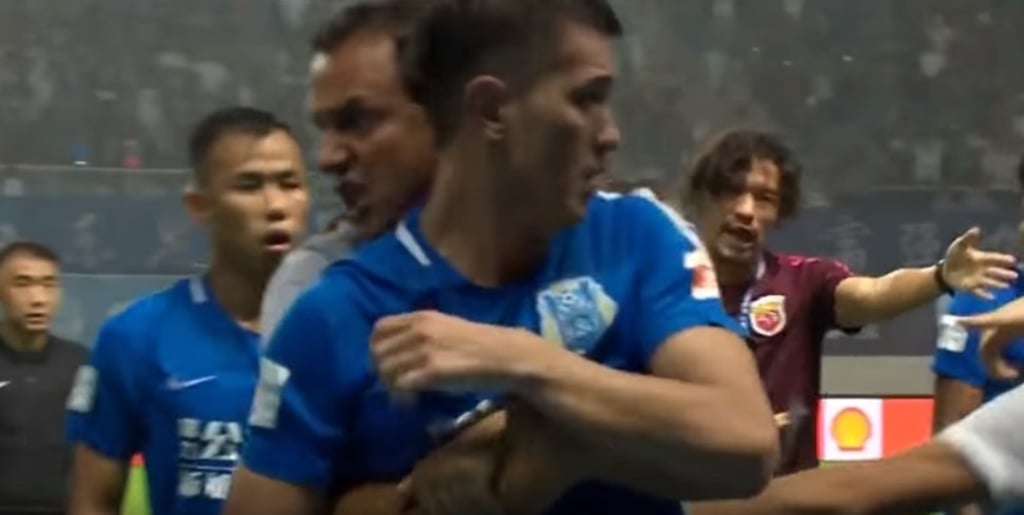Guangzhou R&F players are restrained after the brawl.