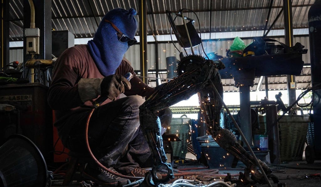 A metalworker welding a statue inspired by aliens from the Alien vs Predator film franchise. Photo: AFP A metalworker welding a statue inspired by aliens from the Alien vs Predator film franchise. Photo: AFP