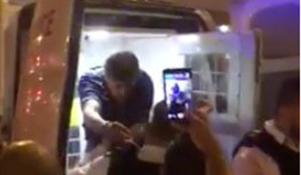 Police officers put a man in the back of a police van after the vehicle collision. Photo: Reuters