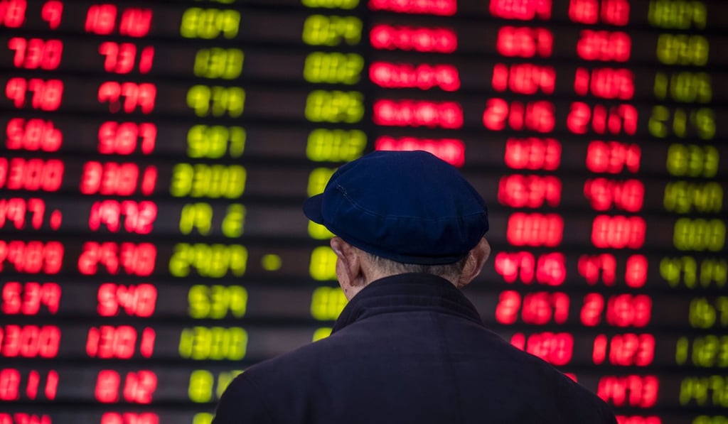 An investor looks at an electronic board showing stock information at a brokerage house in Shanghai . Photo: AFP