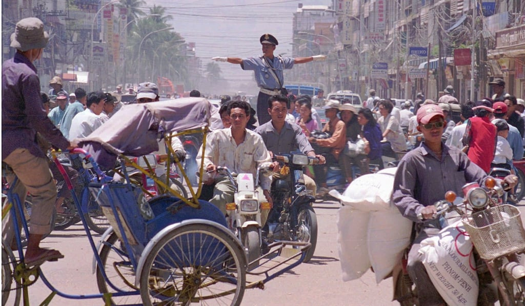 A Cambodian policeman tries to direct traffic at a chaotic intersection in Phnom Penh. Photo: AP