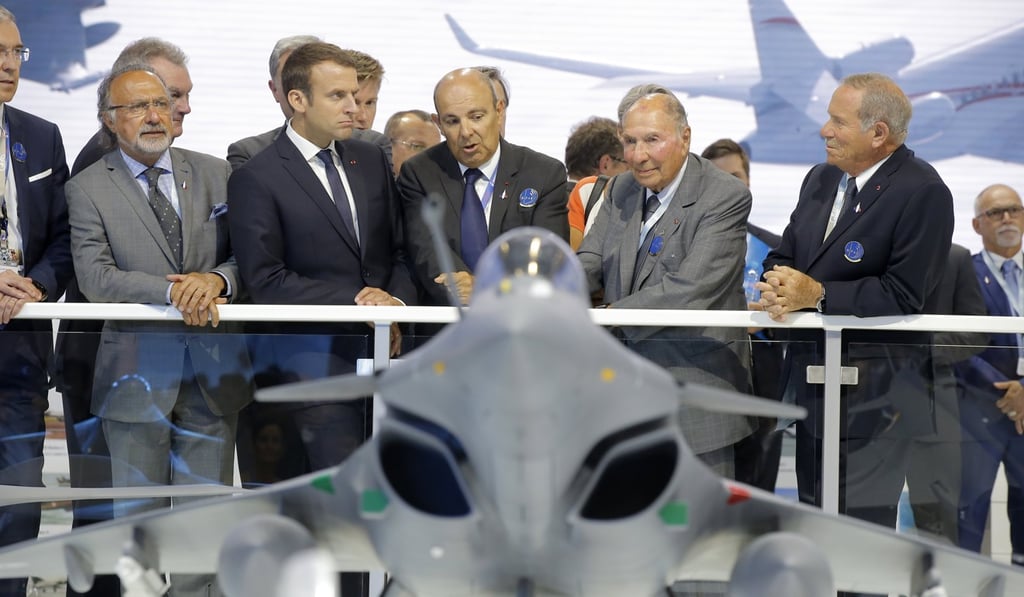 French President Emmanuel Macron, (second left), listens to Dassault Aviation CEO Eric Trappier (centre) while visiting the Paris Air Show in Le Bourget, north of Paris, on June 19. Photo: EPA