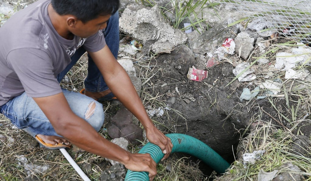 An Indonesian worker drains the escape tunnel. Photo: EPA