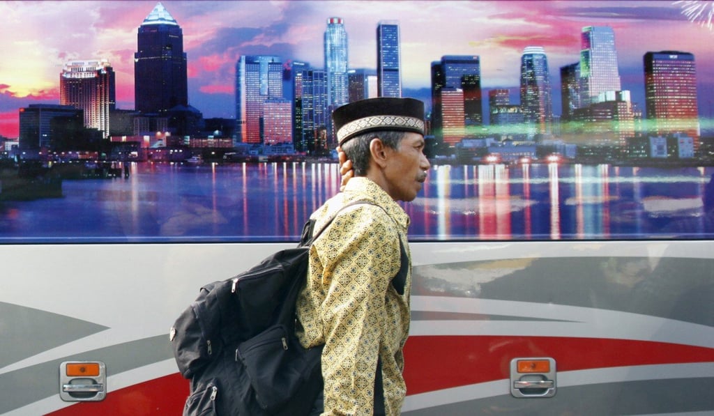 A man arrives at a bus station in Jakarta to travel to his home town to celebrate the end of Ramadan. Photo: AFP