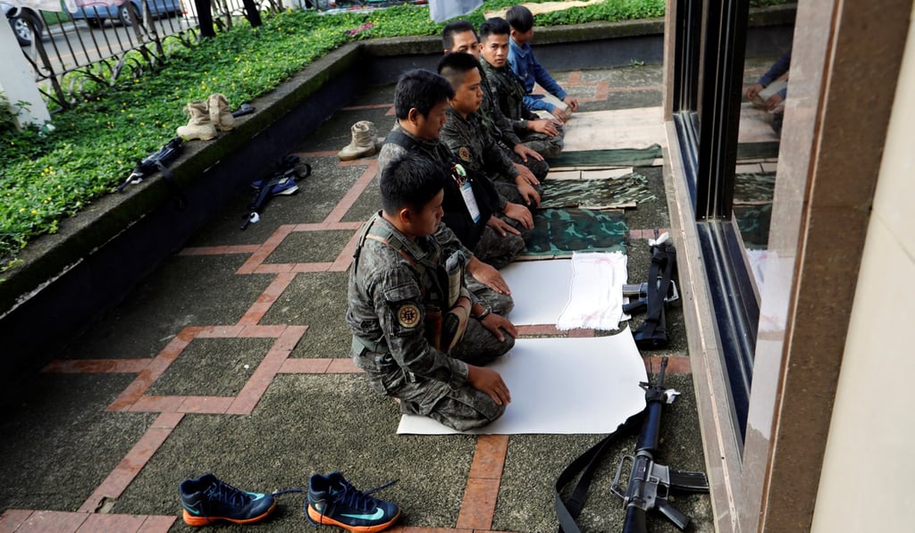 Philippine police officers perform Eid ul-Fitr prayers outside a mosque. Photo: Reuters