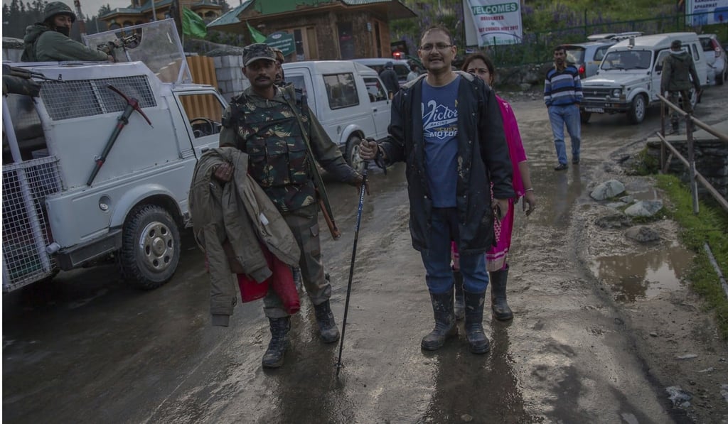 An Indian army soldier helps a tourist after he was rescued from a cable car in Gulmarg. Photo: AP An Indian army soldier helps a tourist after he was rescued from a cable car in Gulmarg. Photo: AP