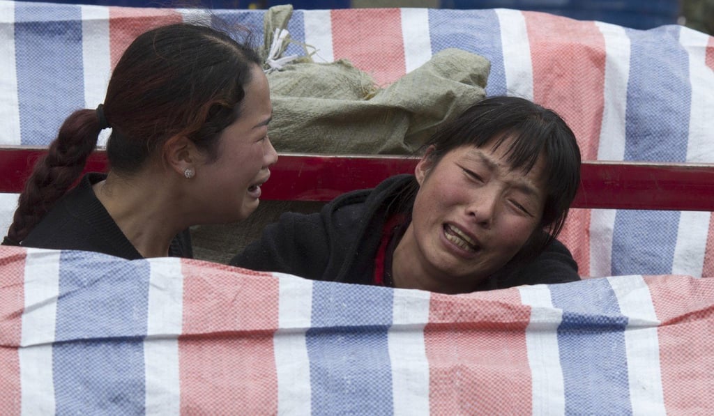 Women grieve near bodies covered by tarpaulin at the site of a landslide in Xinmo village in Sichuan province. Photo: Associated Press Women grieve near bodies covered by tarpaulin at the site of a landslide in Xinmo village in Sichuan province. Photo: Associated Press