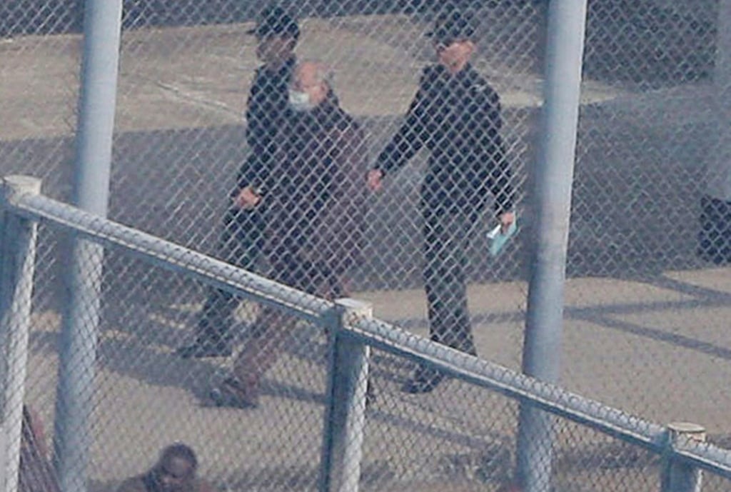 Former chief secretary Rafael Hui is escorted through a yard at Stanley Prison. Photo: Handout