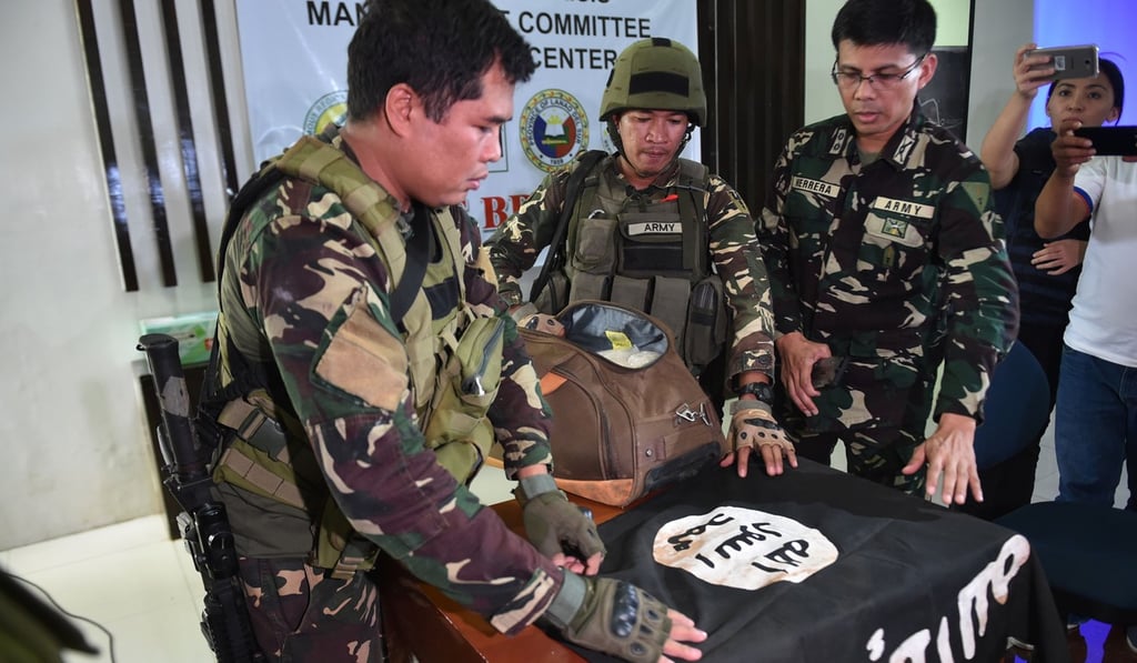 Philippine army personnel prepare to display an Islamic State flag and illegal drugs recovered from a militant position, ahead of a press conference in Marawi, Mindanao, on June 19. Photo: AFP Philippine army personnel prepare to display an Islamic State flag and illegal drugs recovered from a militant position, ahead of a press conference in Marawi, Mindanao, on June 19. Photo: AFP