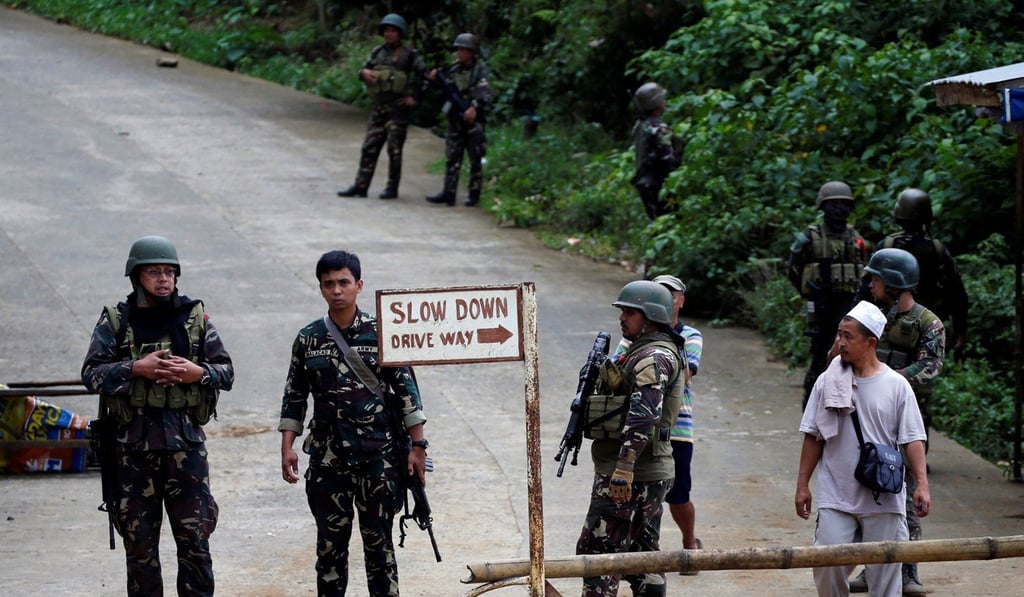 Philippines army soldiers guard a bridge during an operation to retrieve bodies of casualties from the fighting zone in Marawi City. Photo: Reuters