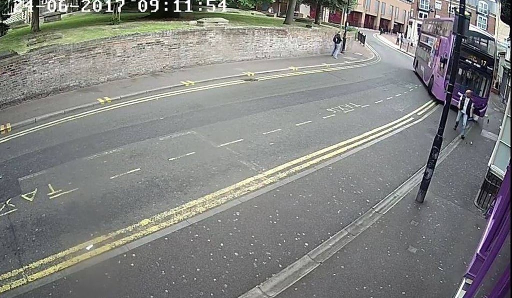 Simon Smith (right) is initially unaware that a double-decker bus is bearing down on him in Reading, England, on Saturday. Photo: BBC / YouTube Simon Smith (right) is initially unaware that a double-decker bus is bearing down on him in Reading, England, on Saturday. Photo: BBC / YouTube