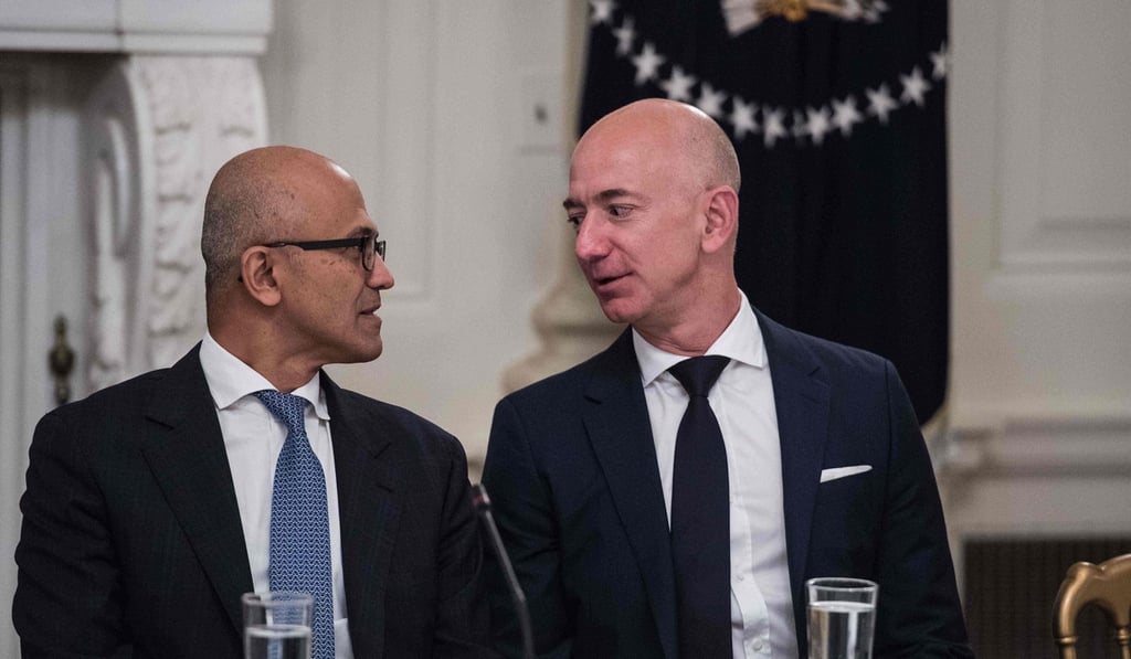Microsoft CEO Satya Nadella (L) and Amazon CEO Jeff Bezos chat during an American Technology Council roundtable at the White House in Washington. Photo: AFP