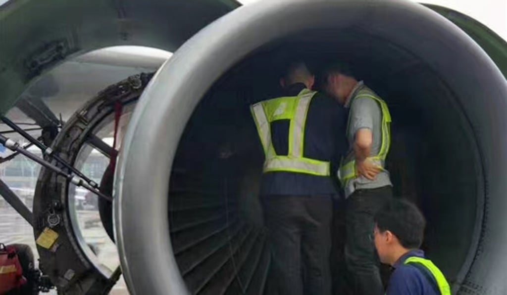 Workers search the engine of China Southern Airlines flight 380 from Shanghai Pudong Airport to Guangzhoufor coins thrown by an elderly woman passenger. Photo: Handout