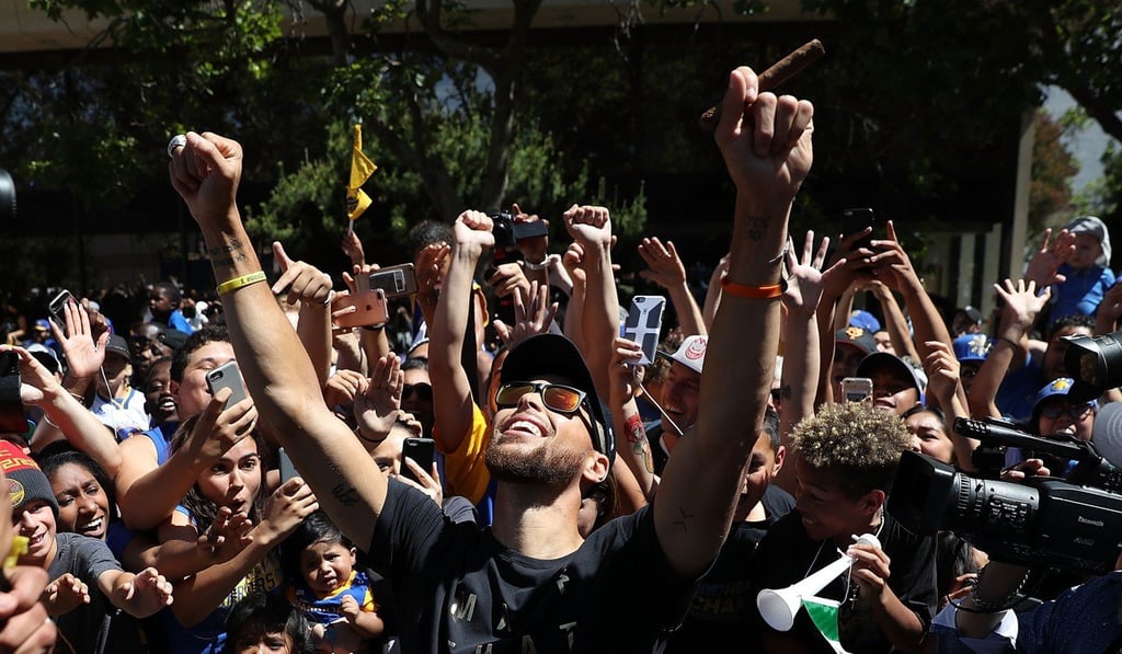 Stephen Curry celebrates with fans during the Warriors’ victory parade. Photo: AFP Stephen Curry celebrates with fans during the Warriors’ victory parade. Photo: AFP