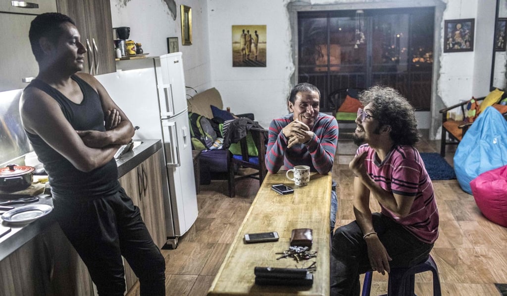 Manuel Bermudez (left), Alejandro Rodriguez (centre) and Victor Prada chat in their home in Medellin, Colombia on June 17. Photo: AFP