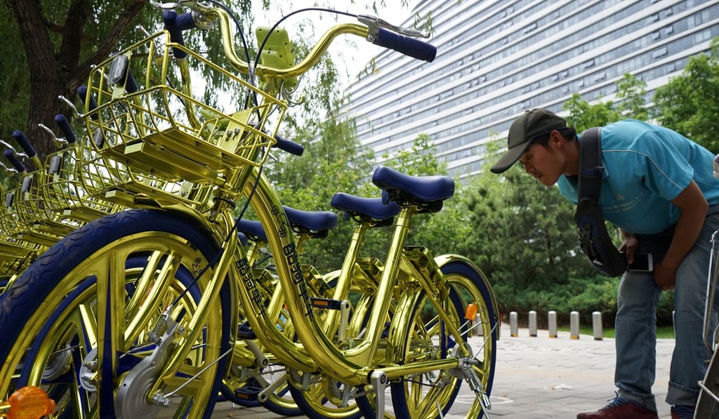 A customer examines another firm’s shared bikes in Beijing. Photo: Reuters