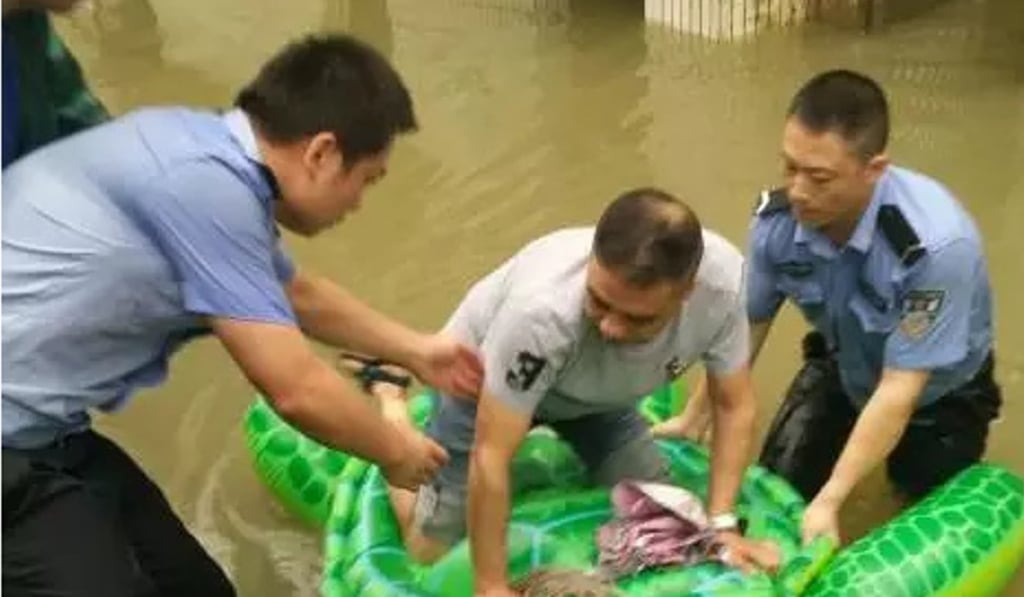 Two police officers help a man on to the makeshift rescue vessel. Photo: Handout