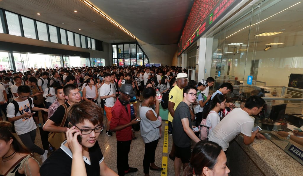 Passengers line up to reschedule travel and refund tickets at Wuhan Railway Station in central China’s Hubei province on Thursday. Photo: Xinhua