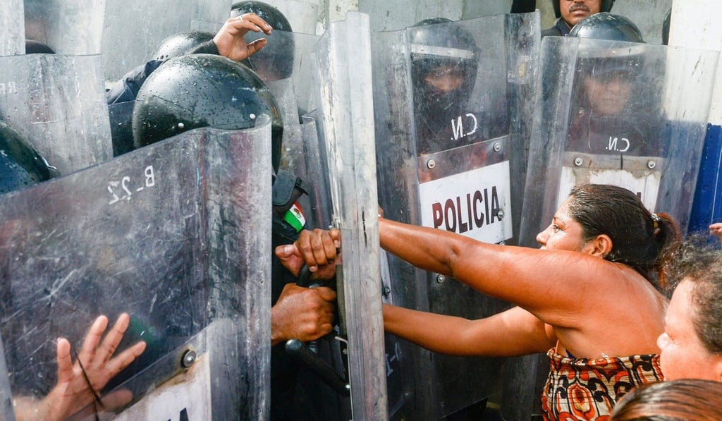 Relatives of inmates struggle with riot policemen outside of Las Cruces prison in Acapulco, Guerrero state following a riot between prisoners which left 28 dead and three wounded, on July 6, 2017. Photo: AFP