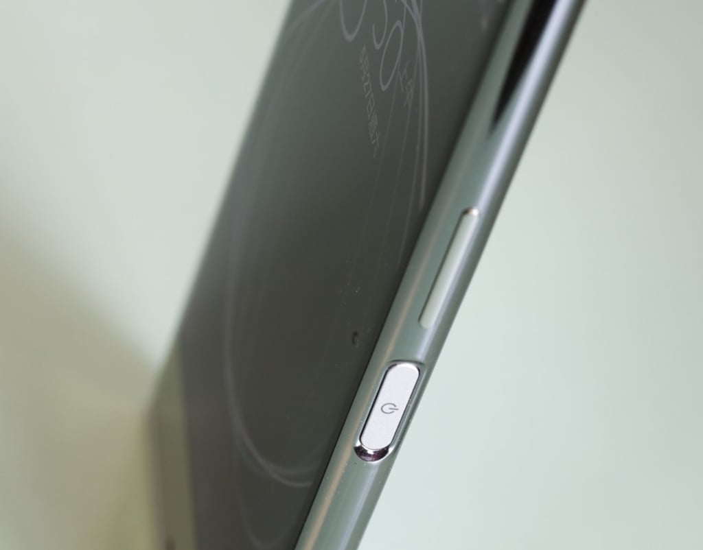 The right side features a fingerprint reader that doubles as the power button, a volume rocker, and a dedicated camera button that launches the camera app. Photo: May Tse