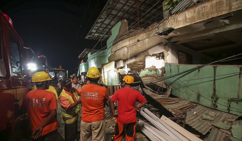 Rescuers conduct search operations in a damaged building in Kananga, Leyte province. Photo: EPA