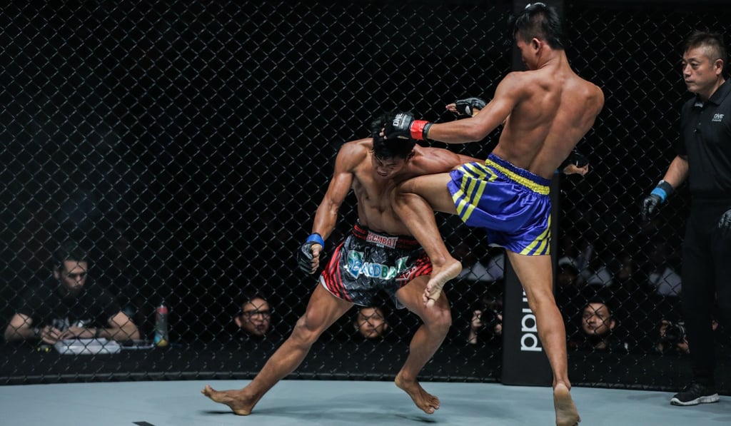 Saw Min Min throws a knee against Kyar Ba Hein during their bout in Yangon.