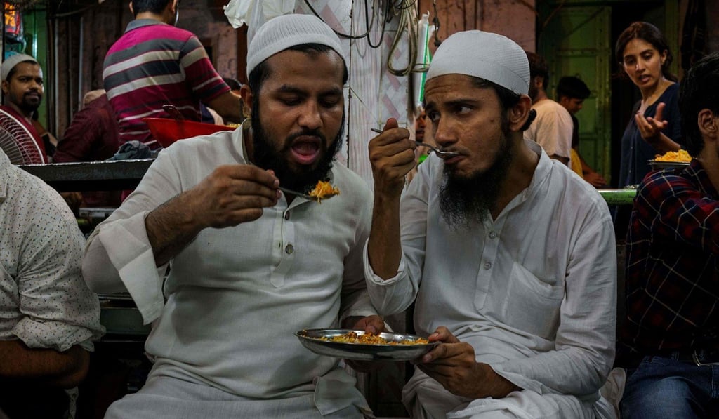Indian Muslim men share food for Eid al-Fitr in the old quarters of New Delhi. Photo: AFP Indian Muslim men share food for Eid al-Fitr in the old quarters of New Delhi. Photo: AFP