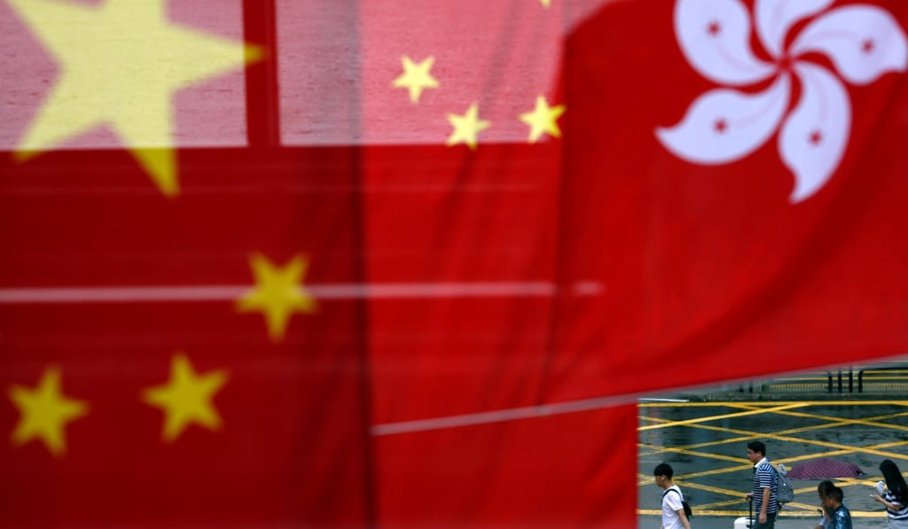 People walk past Chinese and Hong Kong flags after celebrations commemorating the 20th anniversary of Hong Kong's handover to Chinese sovereignty from British rule. Photo: Reuters