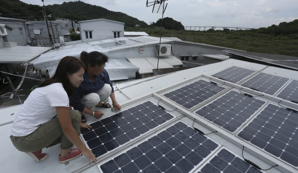 WWF public engagement officer Olivia To Pui-wai (left) and Tai O resident Fung Chuen-tai check on solar panels on Fung’s roof, on June 9. Photo: May Tse