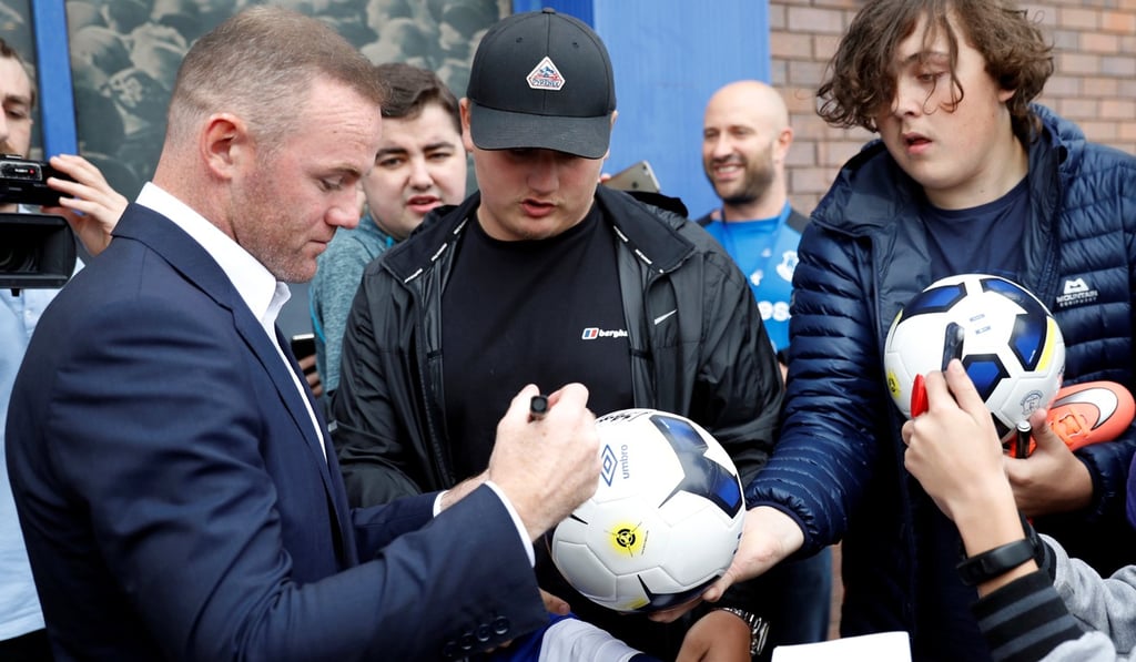 Everton's Wayne Rooney signs autographs for fans. Photo: Reuters