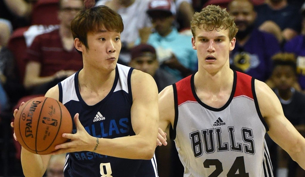Ding Yanyuhang of the Dallas Mavericks looks to pass against Lauri Markkanen of the Chicago Bulls.