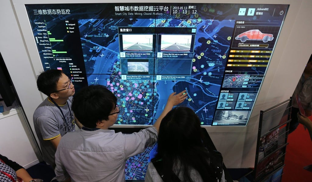 Visitors look at a screen displaying a smart city system at the 18th China Beijing International Hi-Tech Expo, in May 2015. Photo: EPA