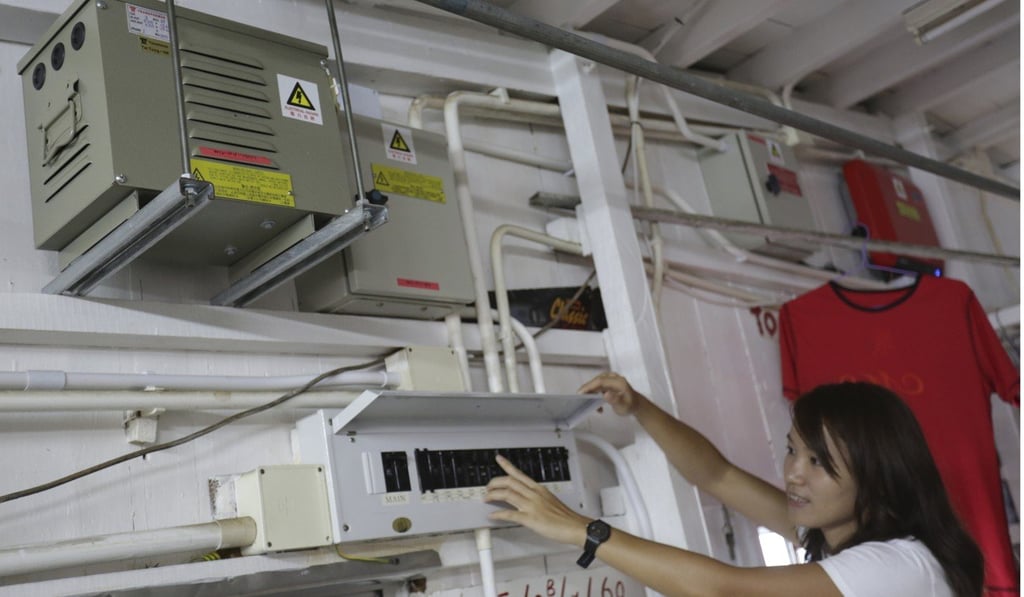 Olivia To of WWF points to the fuse box that distributes electricity within the home from solar panels. Photo: May Tse
