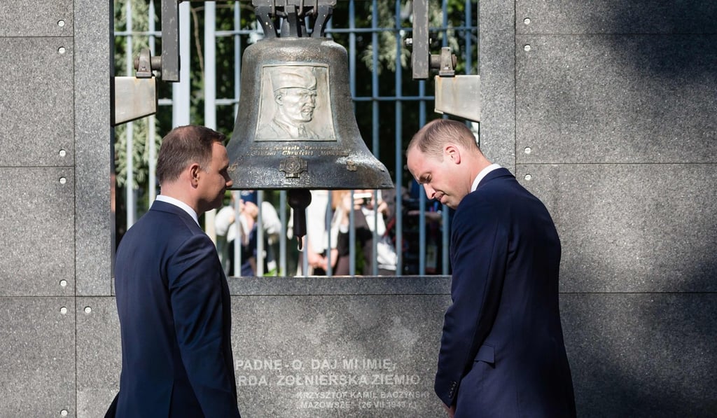 Britain's Prince William, Duke of Cambridge (R) and Polish President Andrzej Duda light candles during a visit to the Warsaw Uprising Museum on July 17, 2017. Photo: AFP