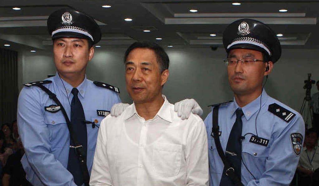 Bo Xilai, centre, wears handcuffs as he stands in a courtroom in Jinan, east China's Shandong province, in this 2013 photo. The fallen Chinese political star was sentenced by a court to life in prison following a scandal that culminated in the country's highest-profile trial in decades. Photo: AFP .