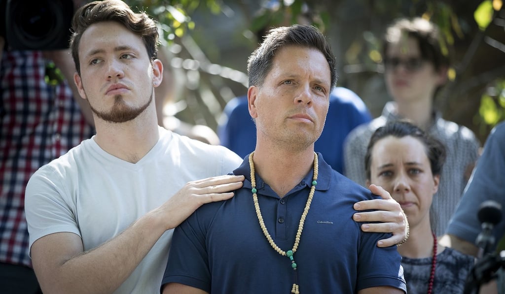 Don Damond is comforted by his son Zach Damond on Monday before he made a statement to the press near his home after Minneapolis police officer shot and killed his fiancé Justine Damond. Photo: TNS