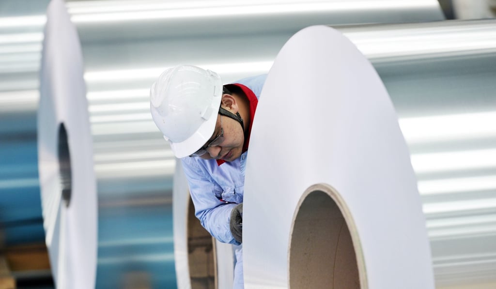 A worker examines coiled aluminum plates at an aluminium plant of Shandong Weiqiao Pioneering Group in Binzhou, Shandong province. Photo: ImagineChina