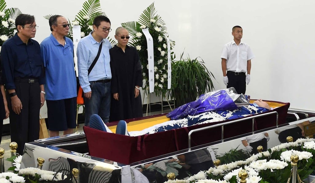 Liu Xia (fourth from left), wife of the late Liu Xiaobo, with her brother Liu Hui (third from left) and Liu Xiaobo’s brothers, standing by his casket at a funeral parlour in Shenyang, Liaoning, on July 15. Photo: EPA/Shenyang Municipal Information Office Liu Xia (fourth from left), wife of the late Liu Xiaobo, with her brother Liu Hui (third from left) and Liu Xiaobo’s brothers, standing by his casket at a funeral parlour in Shenyang, Liaoning, on July 15. Photo: EPA/Shenyang Municipal Information Office