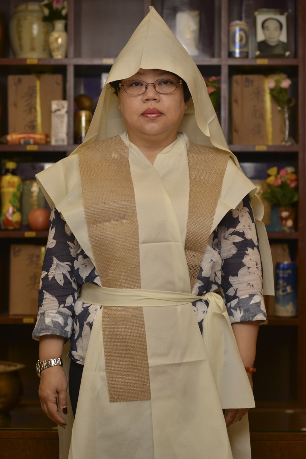 Teresa Law, proprietor of Wing Fook Funeral Home, dressed in the white cotton and sackcloth funeral attire worn by close family members at a funeral. Photo: Antony Dickson