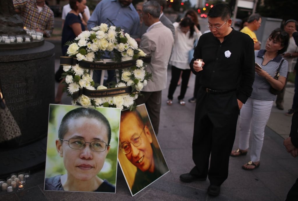 Chinese exile Yang Jianli holds a candle during a vigil in memory of Liu Xiaobo in Washington. Photo: AFP Chinese exile Yang Jianli holds a candle during a vigil in memory of Liu Xiaobo in Washington. Photo: AFP