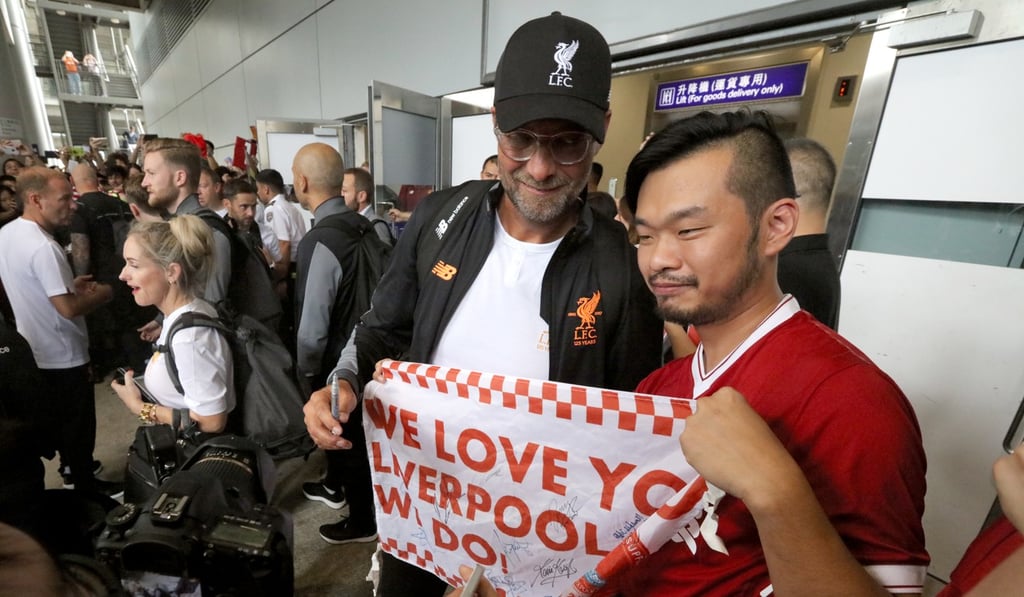 Jurgen Klopp signs a fan’s flag as Liverpool arrived in Hong Kong. Photo: Felix Wong