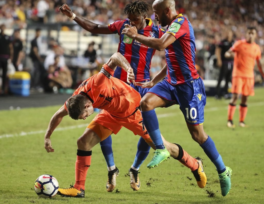 Liverpool’s James Milner stumbles following a tackle from Crystal Palace’s Andros Townsend.