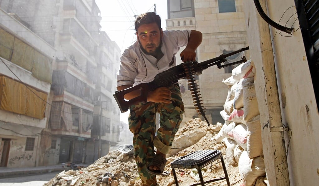 A Free Syrian Army fighter takes cover during clashes with Syrian Army in the Salaheddine neighbourhood of central Aleppo in 2012. Photo: Reuters