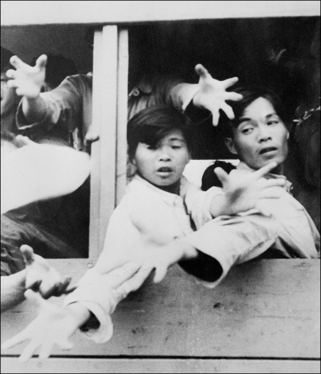 Some of the 60,000 mainland Chinese who arrived illegally in Hong Kong in May 1962 hold out their hands from a lorry asking for food as they are expelled to China by the Hong Kong authorities. Photo: AFP