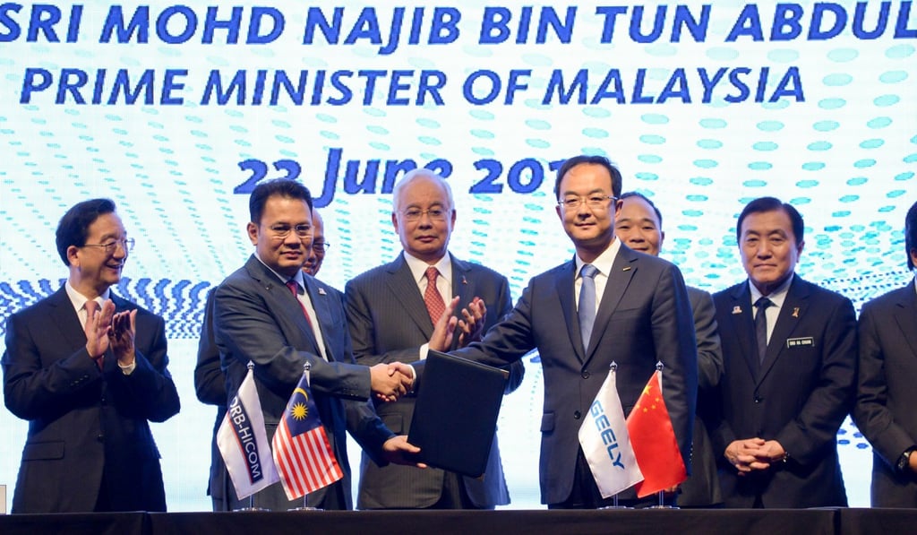 Malaysian Prime Minister Najib Razak, centre, applauds during the signing ceremony in Kuala Lumpur between China's Zhejiang Geely Holding Group and Malaysia's carmaker Proton. Photo: Xinhua