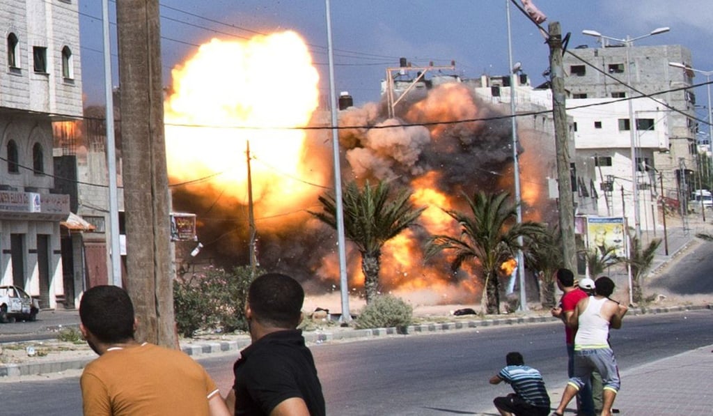 Palestinian men react as a bomb from an Israeli air strike hits a house in Gaza City in 2014. The Israel-Palestine dispute has been going on for years, but no resolution in sight. Photo: AFP