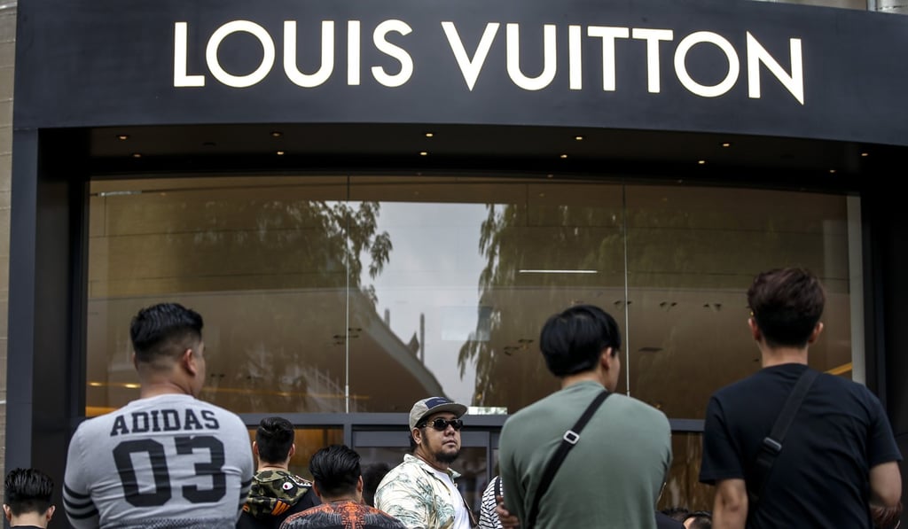 Customers queue to enter a Louis Vuitton store in Singapore. Photo: EPA Customers queue to enter a Louis Vuitton store in Singapore. Photo: EPA