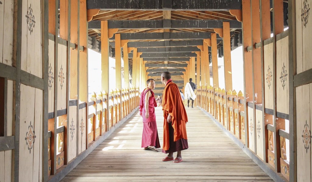 Two monks walk across the wooden bridge to Punakha Dzong on their way to and from early morning prayers in Bhutan. Photo: GO 48HRS